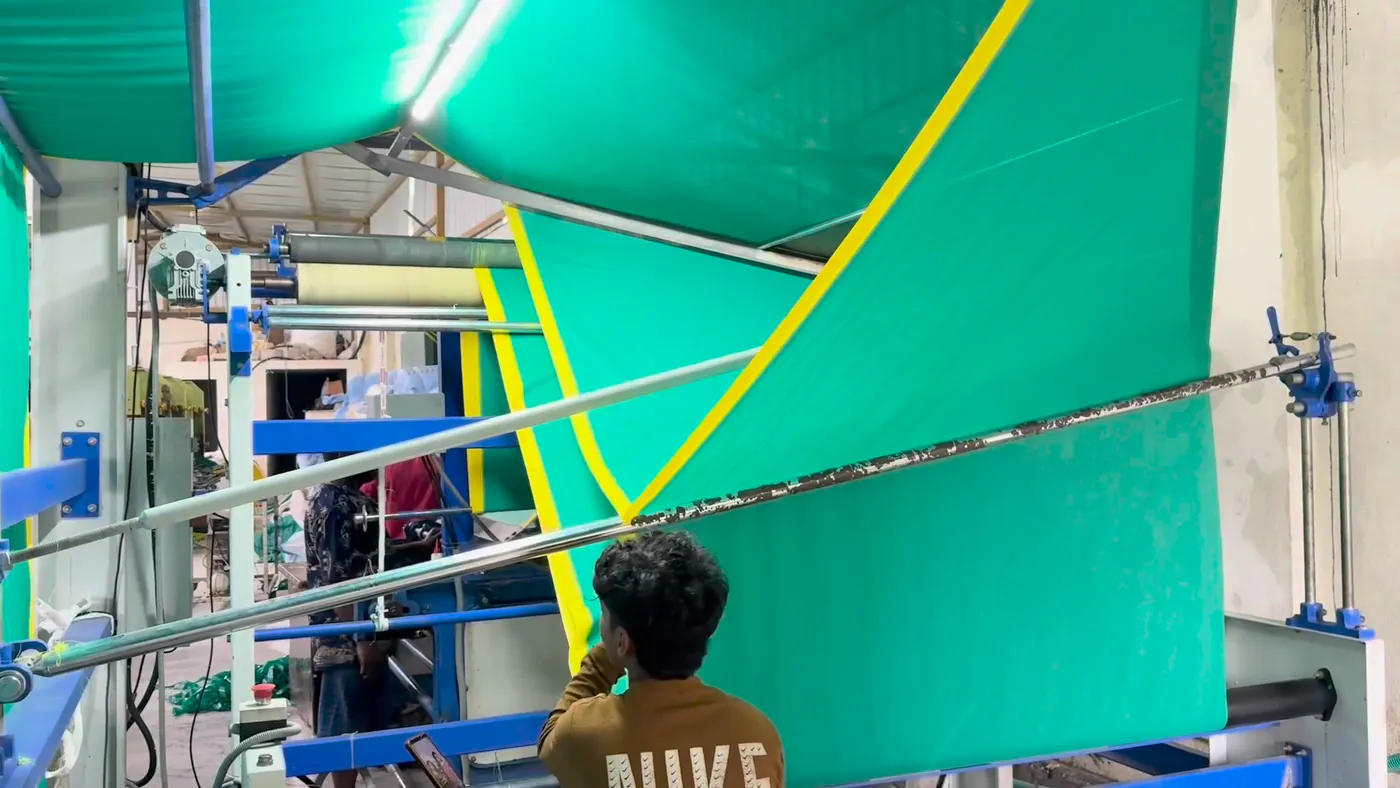 A worker guiding the cloth through the finishing frame